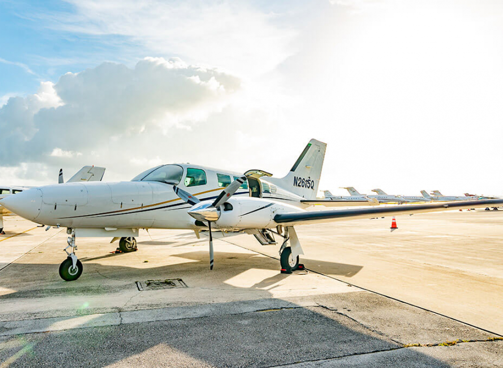 A Cessna 402C Private turboprop plane sitting on a runway for Noble Air Charter in Miami